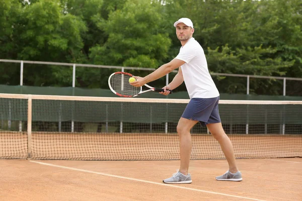 Mladý muž hrát tenis na kurtech — Stock fotografie