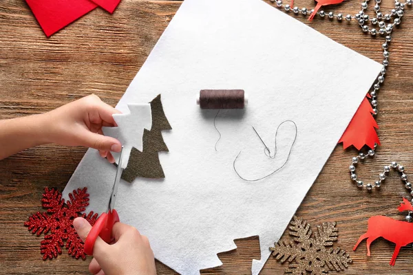Little child cutting out Christmas tree from felt at table — Stock Photo, Image