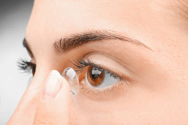 Mujer joven poniendo lente de contacto — Foto de Stock