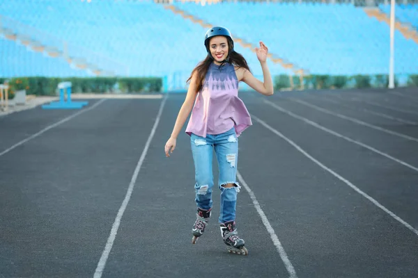 Молодая женщина катается на роликах по стадионной дорожке — стоковое фото