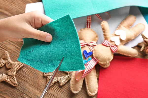 Niño pequeño cosiendo el árbol de Navidad de fieltro en la mesa — Foto de Stock