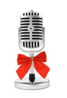 Beyaz arka plan üzerinde yay ile mikrofon. Noel müzik konsepti