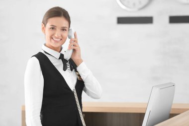 Kadın resepsiyonist otel telefonda konuşuyor