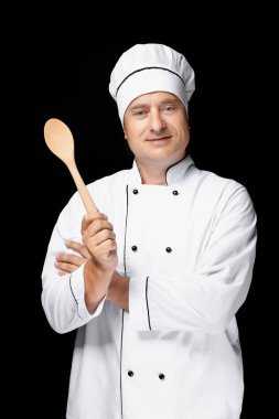 Tek tip holding tahta kaşık siyah arka plan üzerine erkek şefi