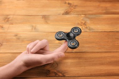 Modern spinner ahşap arka plan üzerinde haddeleme kadın