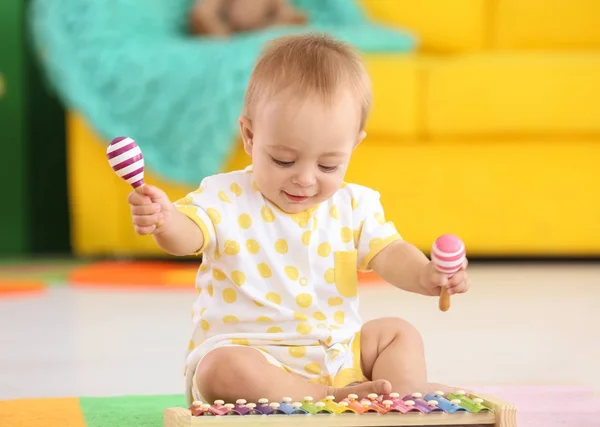 Schattige kleine baby spelen met muziekinstrumenten thuis — Stockfoto