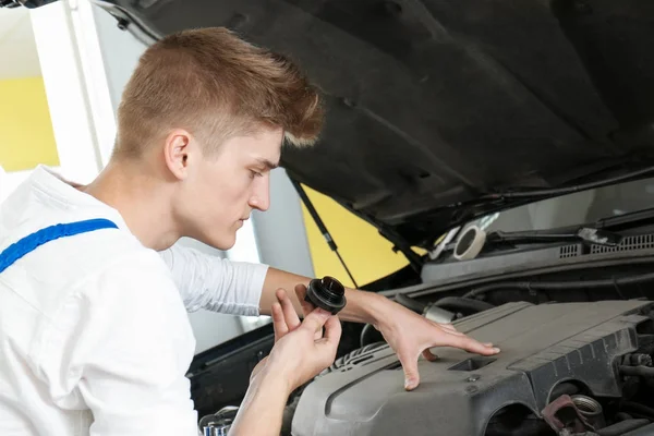 Unga mekaniker reparerar bilen i bodyshop — Stockfoto