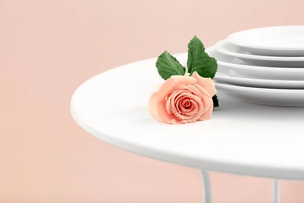 Роза абрикоса рядом с грудой тарелок — стоковое фото