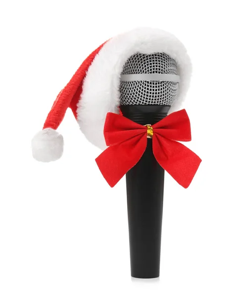Μικρόφωνο σε το καπέλο Santa με φιόγκο σε λευκό φόντο. Χριστουγεννιάτικη μουσική έννοια — Φωτογραφία Αρχείου