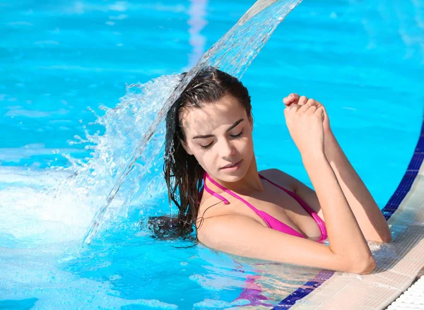 Ung kvinna i poolen på resort — Stockfoto