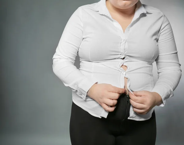 Übergewichtige Frau versucht Hemd hochzuknöpfen — Stockfoto
