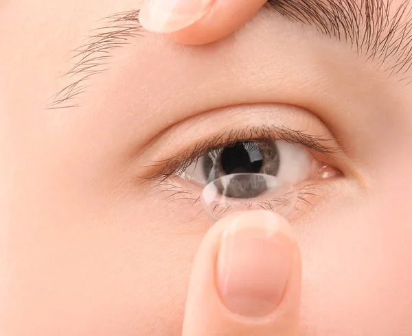Ung kvinna sätta kontaktlins, närbild — Stockfoto
