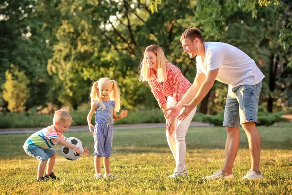 Familia feliz jugando al fútbol en el parque en un día soleado — Foto de Stock