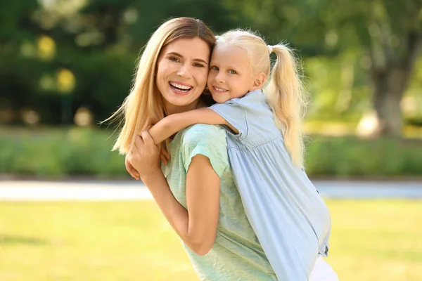 Lycklig kvinna med dotter i parken på solig dag — Stockfoto