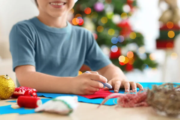 Netter Junge bastelt Weihnachtssocke aus Filz auf dem Tisch — Stockfoto