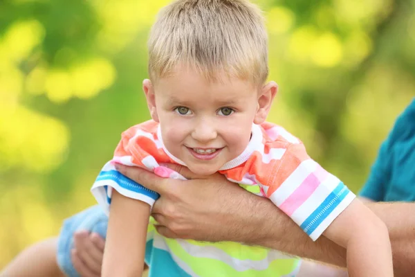 Счастливый мальчик играл с отцом в парке в солнечный день — стоковое фото