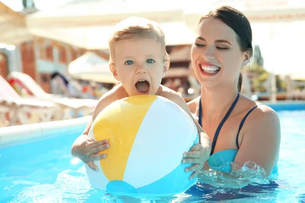 Mor och barn med uppblåsbar boll i poolen — Stockfoto