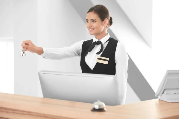 Vrouwelijke receptioniste met kamersleutel in hotel — Stockfoto