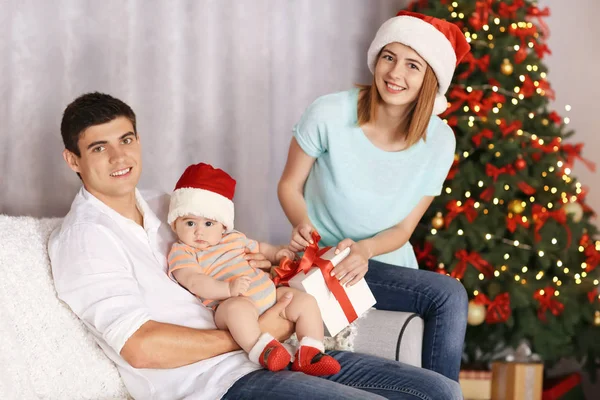 Ευτυχείς γονείς με μικρό μωρό στην διακόσμηση για το δωμάτιο Χριστούγεννα — Φωτογραφία Αρχείου