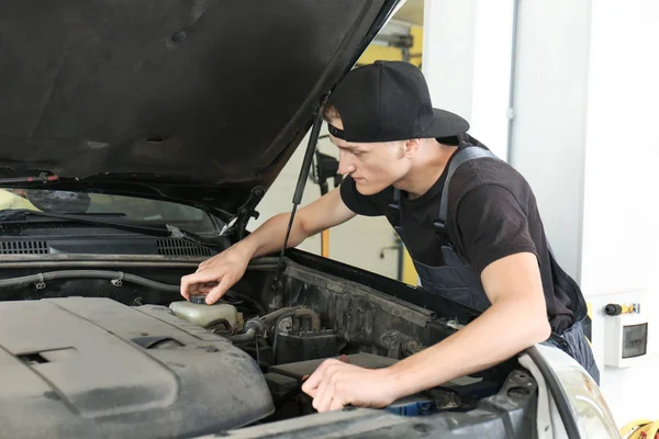 Junger Mechaniker repariert Auto in Karosseriebau — Stockfoto