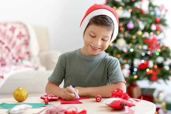 Netter Junge bastelt Weihnachtssocke aus Filz auf dem Tisch — Stockfoto