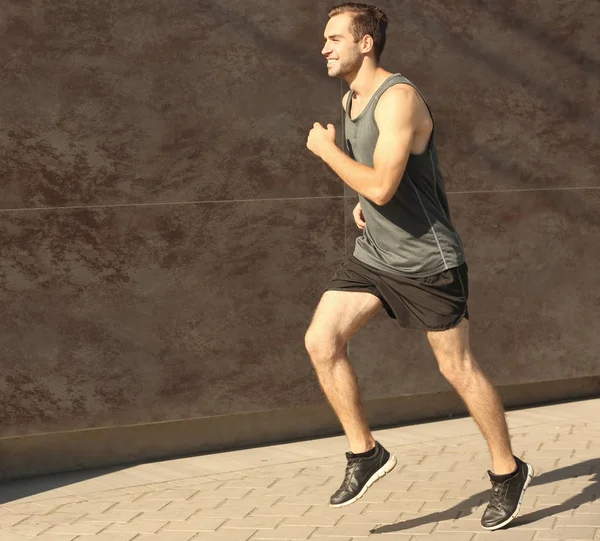 Спортивный молодой человек бежит — стоковое фото