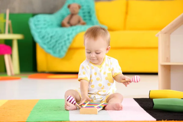 Söt liten bebis leker med musikinstrument hemma — Stockfoto