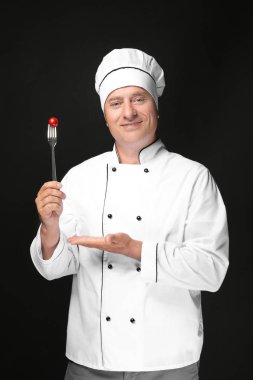 Kiraz domates siyah arka plan üzerine çatalla Tekdüzen holding erkek şefi