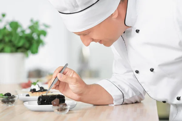 Mannelijke chef-kok koken dessert in keuken — Stockfoto