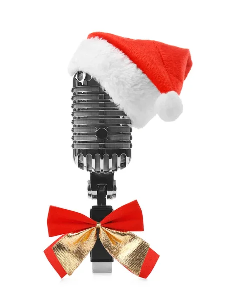 Μικρόφωνο σε το καπέλο Santa με φιόγκο σε λευκό φόντο. Χριστουγεννιάτικη μουσική έννοια — Φωτογραφία Αρχείου