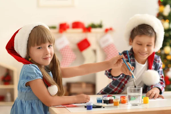 Lindos niños pintando cuadros para Navidad en la mesa —  Fotos de Stock