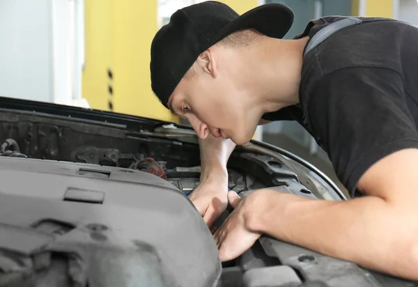 Unga mekaniker reparerar bilen i bodyshop — Stockfoto