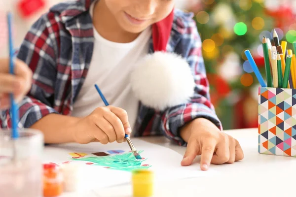 Leuke jongen fir kerstboom aan tafel schilderen — Stockfoto