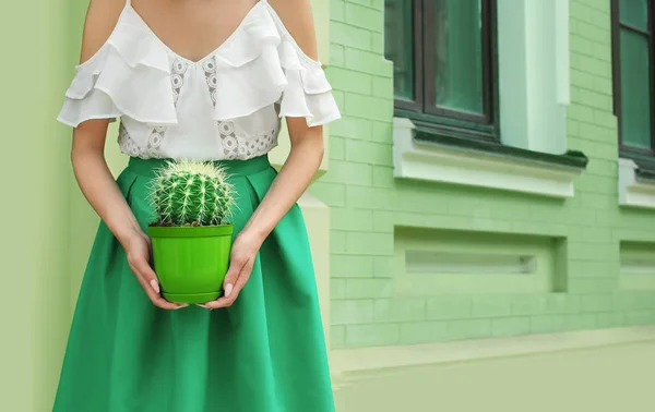 Hipster femme en jupe verte tenant cactus à l'extérieur — Photo