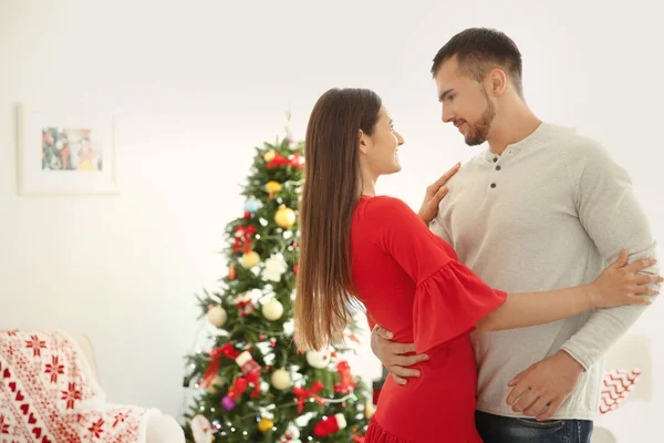 Joven pareja feliz en la habitación decorada para Navidad — Foto de Stock