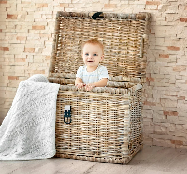 Cute little baby in wicker box at home