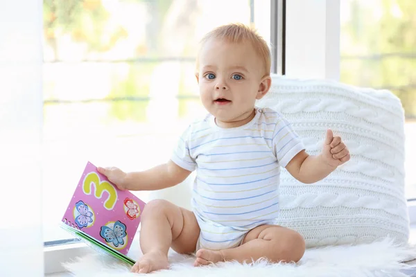 逗人喜爱的小婴孩与书坐窗台在家 — 图库照片