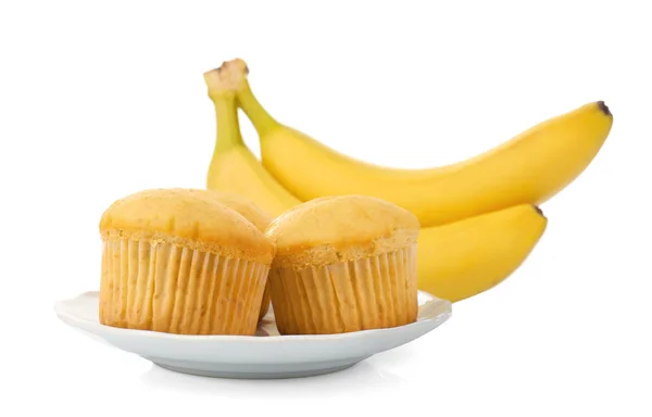 Bananes fraîches et muffins sur assiette, isolés sur blanc — Photo