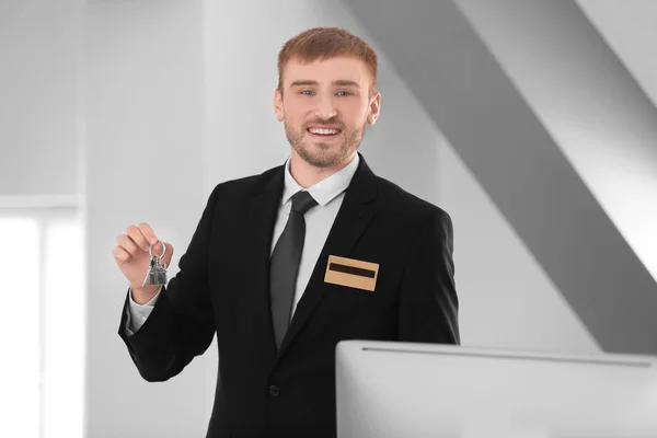 Recepcionista masculino com chave de quarto no hotel — Fotografia de Stock