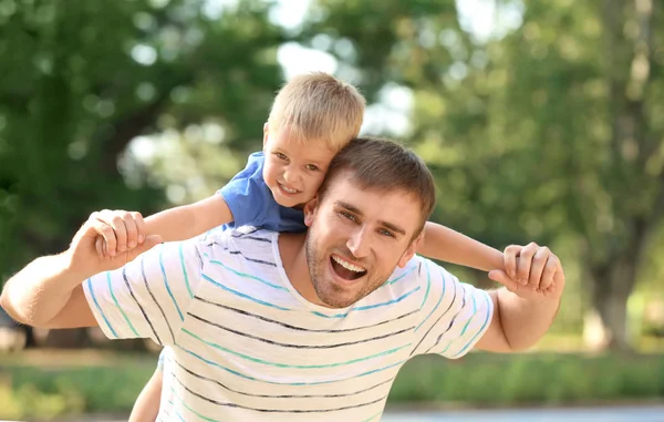 Homem feliz com filho no parque no dia ensolarado — Fotografia de Stock