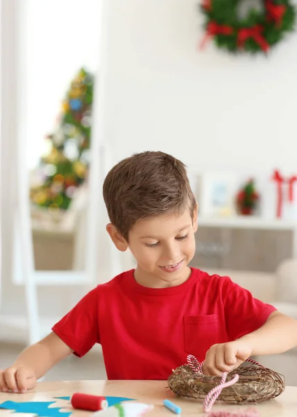 Mignon garçon décoration de Noël couronne sur la table — Photo