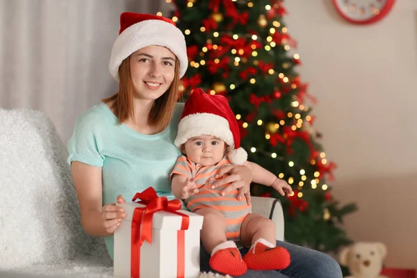 Glad ung mor med lilla baby i dekorerad för Christmas room — Stockfoto