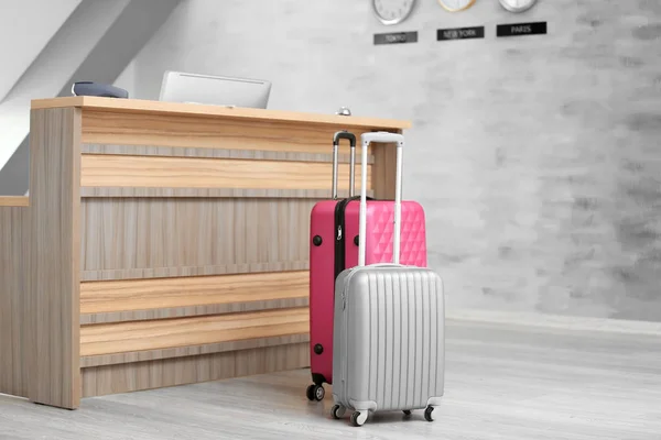Suitcases near reception desk in hotel — Stock Photo, Image