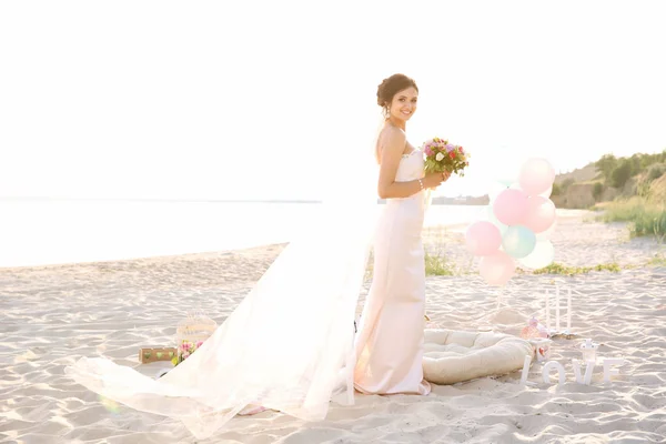 Hermosa novia con ramo de bodas en la playa — Foto de Stock