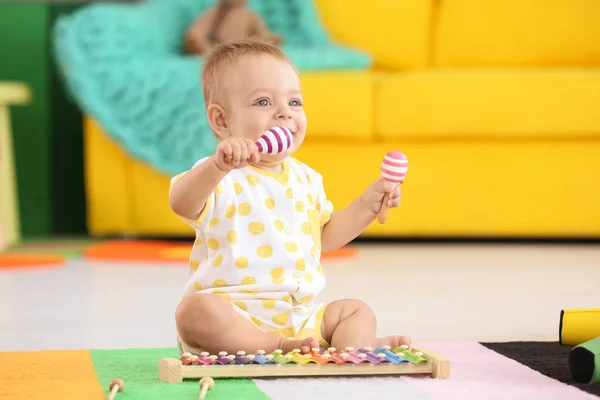 Schattige kleine baby spelen met muziekinstrumenten thuis — Stockfoto