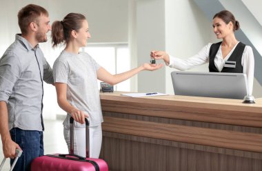 Genç çift Resepsiyonda otel odası anahtarı alma