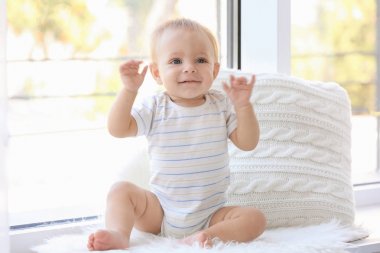 Pencere pervazına evde oturan şirin bebek