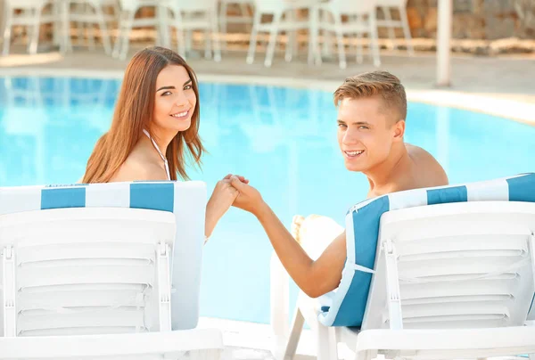Happy νεαρό ζευγάρι αναπαύεται κοντά πισίνα θέρετρο — Φωτογραφία Αρχείου