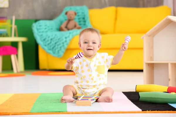 Lindo bebé jugando con instrumentos musicales en casa —  Fotos de Stock