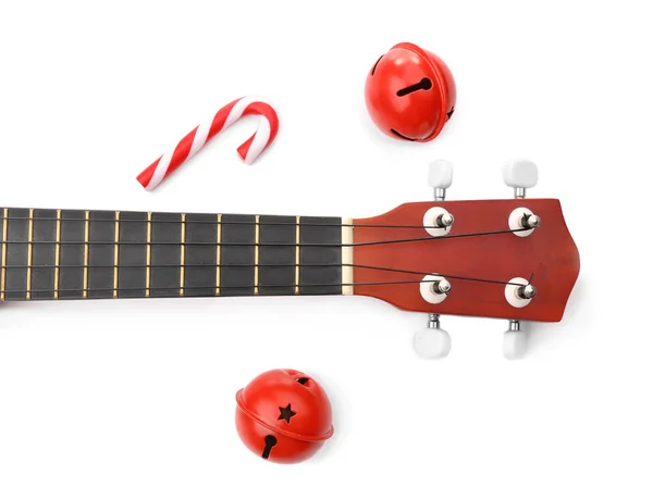 Guitarra, sinos e cana-de-açúcar sobre fundo branco. Conceito de música natalina — Fotografia de Stock